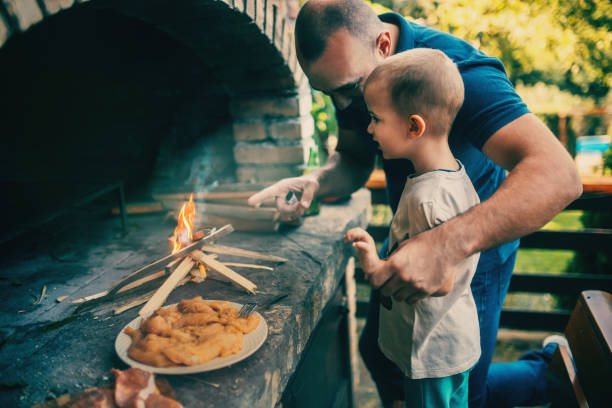istock Dad is preparing a barbecue with his son in the yard 1734818307