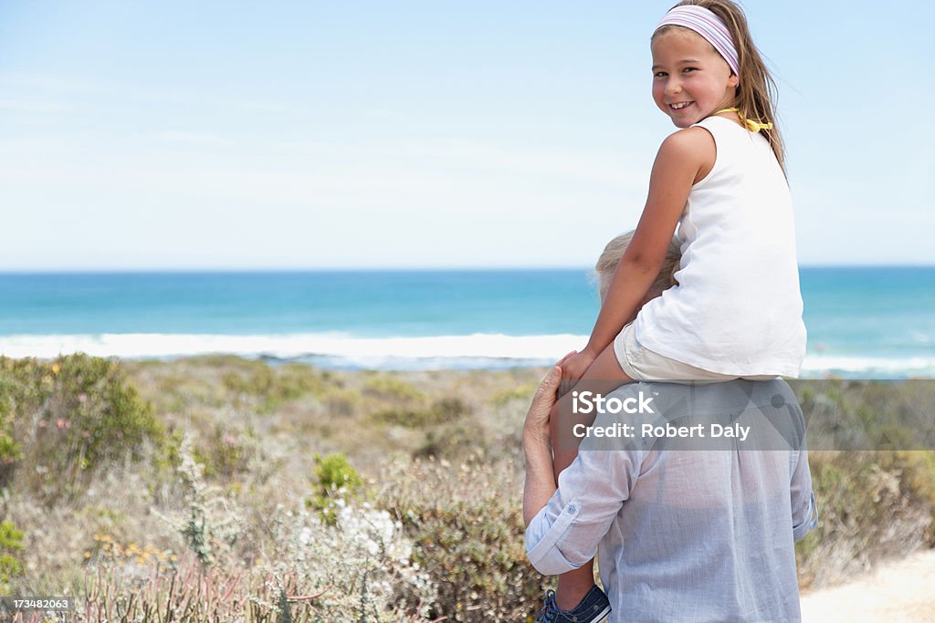Babka nosić Wnuczka na ramionach na plaży - Zbiór zdjęć royalty-free (6-7 lat)