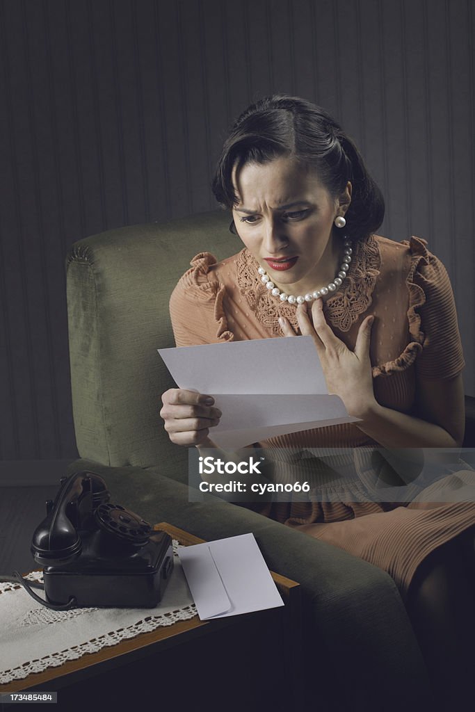 Junge Frau Lesen einer Nachricht mit sorgen Ausdruck - Lizenzfrei 1950-1959 Stock-Foto