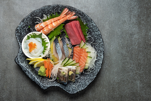 mixed sashimi sushi plate in japanese restaurant on grey background