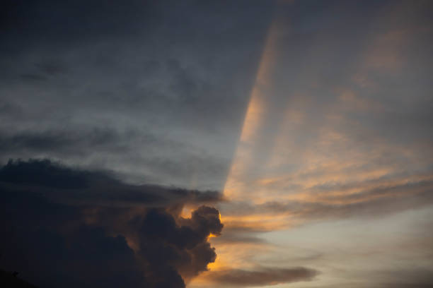 golden sun rays on dark cloud and grey sky. natural sun beams in evening.