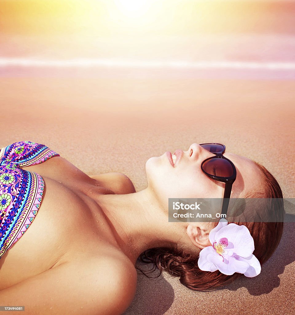 Sexy woman on the beach Closeup of beautiful female lying down on sea shore on sunset background, relaxed on the beach, luxury spa resort, summer holiday and vacation concept Adult Stock Photo