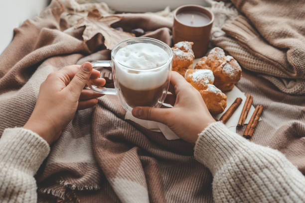 Cup of coffee in hands, cozy autumn