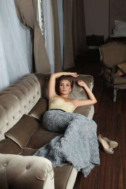 istock Young cute woman resting on velvet brown sofa 1734952539