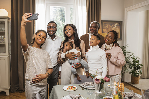 Portrait of happy African American multi-generation family at dining table looking at camera.