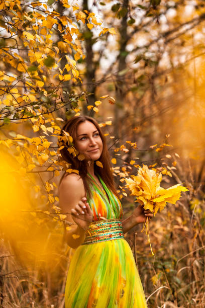 Portrait of lovely lady in yellow colored dress posing in fall forest, dreaming looking up away. Stylish lovely woman model in natural autumn park of nature. Golden autumn concept. Copy ad text space retrato de una dama encantadora con un vestido de color amarillo posando en el bosque de otoño, soñando mirando hacia arriba. modelo de mujer encantadora con estilo en el parque natural de otoño de la naturaleza. concepto de otoño dorado. copiar espaci