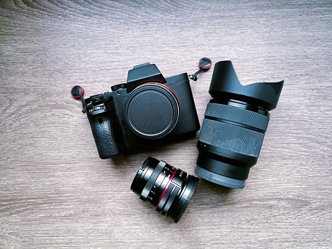 SLR Single-lens reflex professional camera on wooden table and concrete wall background