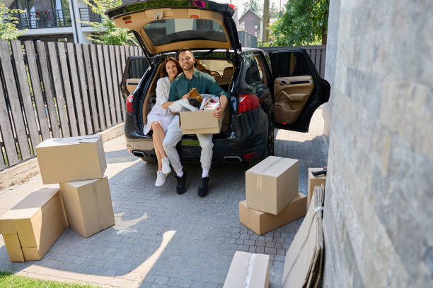 istock Smiling husband and wife are sitting with boxes in open trunk 1734997125