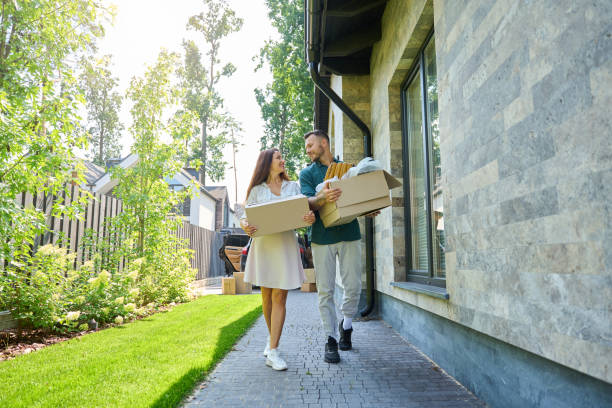 istock Smiling man and his wife are carrying boxes from open trunk 1734997134