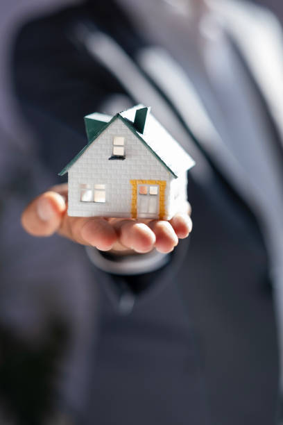 businessman with house model in hand
