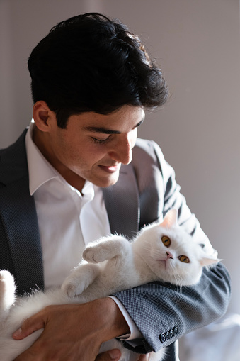 Young man hugging the cat in the office