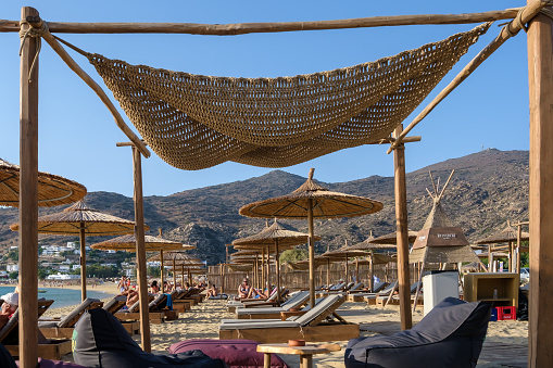 Ios, Greece - September 8, 2023 : View of luxury sun beds and sun umbrellas at the famous Mylopotas beach in Ios Greece