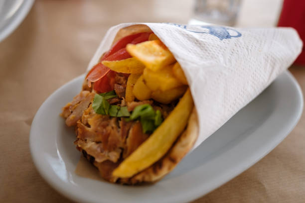 View of a delicious Greek pita gyro filled with French fries, tomato and tzatziki in Ios Greece