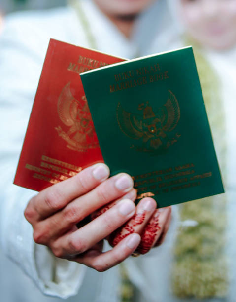 istock Bride and groom holding Indonesian marriage certificate 1735034954