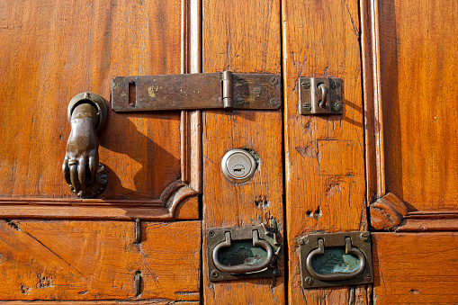 Close-up view to a wooden door with door rings and lock in historic town Barichara, Colombia