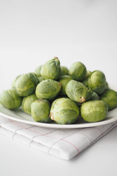 신선한 브뤼셀 콩나물은 흰색 바탕에 상자에 들어 있습니다 - brussels sprout 뉴스 사진 이미지