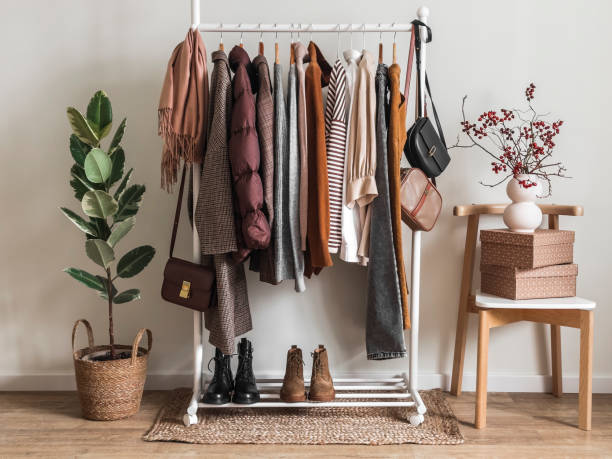 Cozy dressing room. Floor hanger with women's seasonal autumn winter clothes. Coats, pullovers, jackets, shirts, shoes - comfortable casual women's clothing Cozy dressing room. Floor hanger with women's seasonal autumn winter clothes. Coats, pullovers, jackets, shirts, shoes - comfortable casual women's clothing corduroy jacket stock pictures, royalty-free photos & images