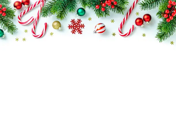 Christmas frame made of ornaments and candy canes on white background Christmas frame made of ornaments and candy canes on white background