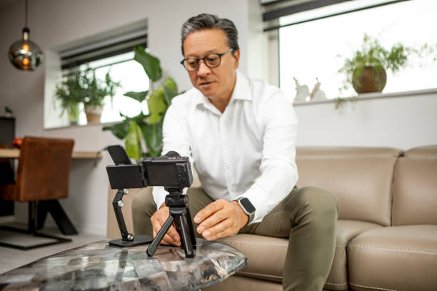 istock Handsome chinese business man vlogging using social media at home 1735154836
