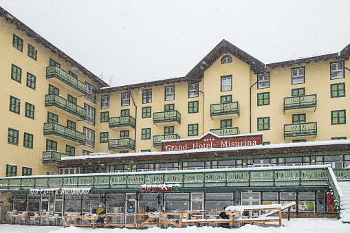 Misurina, Auronzo di Cadore, Italy - Apr 13th, 2023: View of Grand Hotel Misurina facade in a winter day; Dolomites, Italy