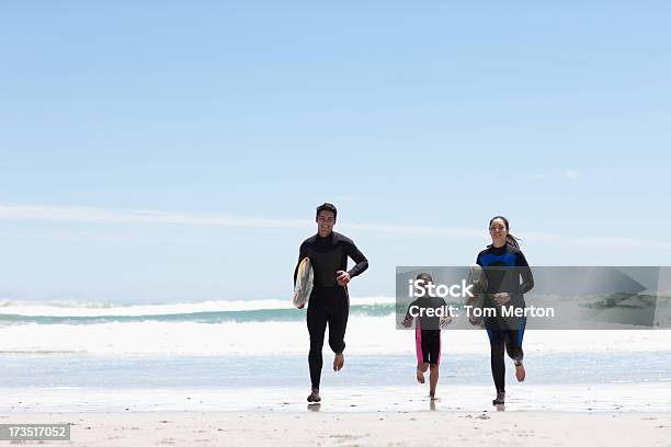 Photo libre de droit de Famille Avec Des Planches De Surf Sur La Plage De Jogging banque d'images et plus d'images libres de droit de 25-29 ans