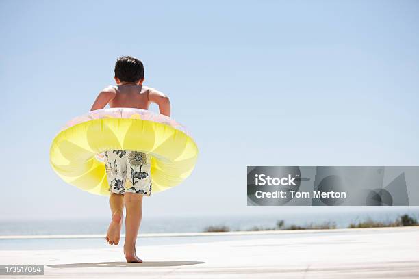 Menino Com Boia Saltando Fora Do Lago Infinito - Fotografias de stock e mais imagens de Boia - Insuflável - Boia - Insuflável, Criança, Infância