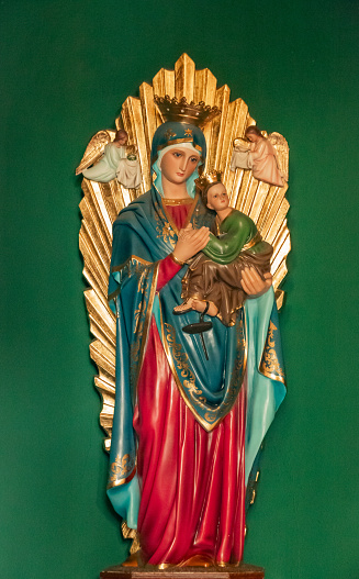 Image of Our Lady of Perpetual Help vertically with green background on altar