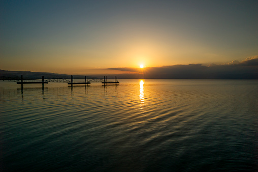 Sunrise on the Sea of Galilee, the trestle stretches into the middle of the lake, Kibbutz Ginosar, Israel.