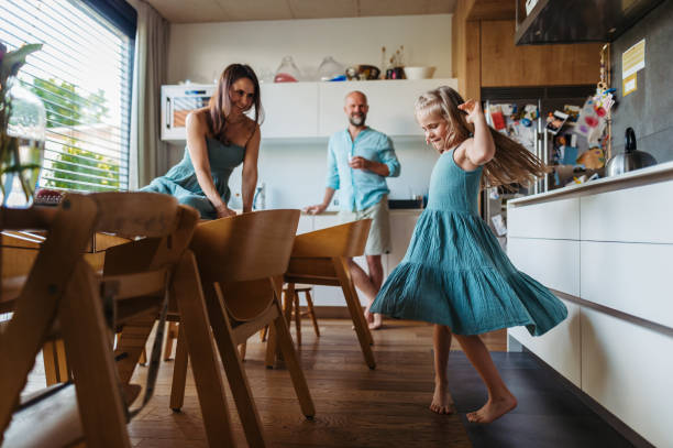 istock Little girl dancing in the kitchen, while parents watching her. 1735218557