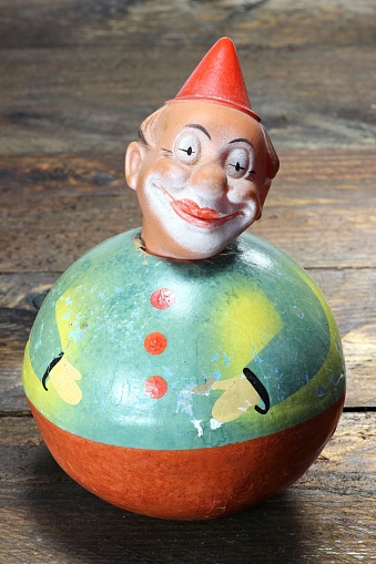 antique roly-poly doll on wooden background