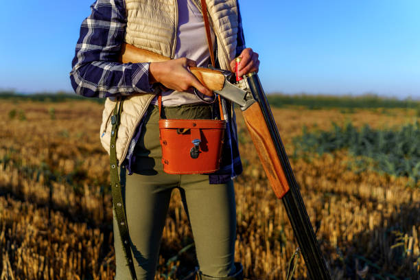 istock Young female hunter checking the bullets in her shotgun. 1735233517