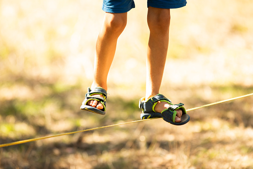 Close-up of a child walking on a tightrope during an obstacle course at a festival