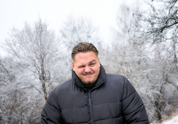 istock Man in a thick winter jacket looking mischievously into the camera 1735273944