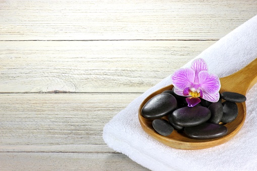 basalt stones for hot stone massage with accessories on wooden background