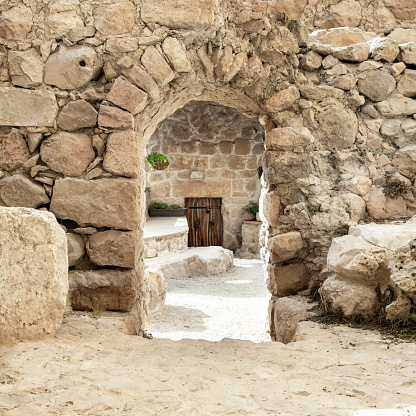 Doorway with an arch in a ancient medieval stone wall