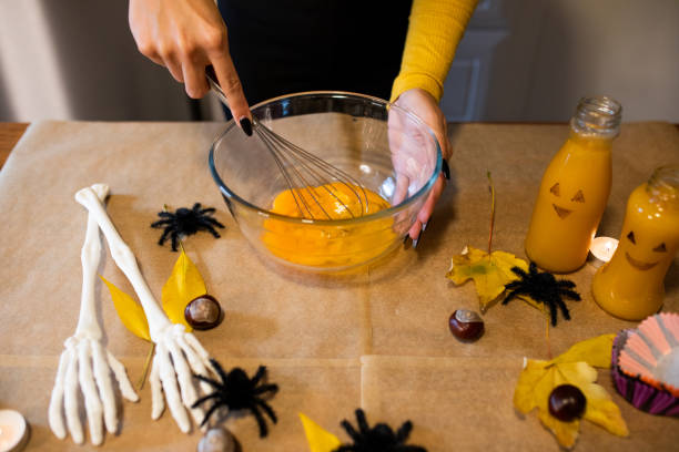 istock Young woman making muffins for Halloween 1735312267