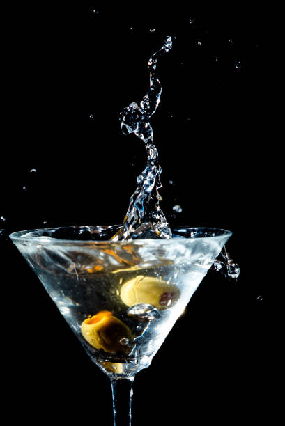 istock Olive splashing into a martini glass 1735323444