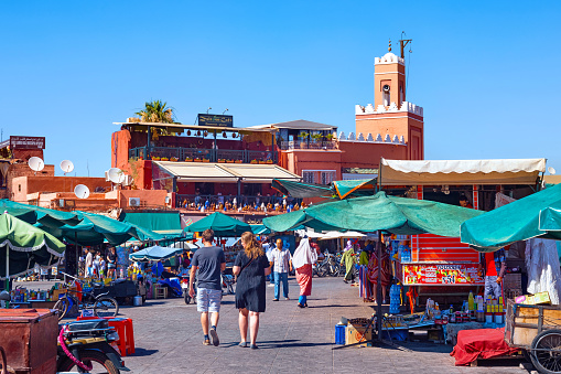 Marrakesh, Morocco - June 05, 2017: View of the market on the famous Jemaa el-Fnaa in the medina of Marrakesh on a sunny day.