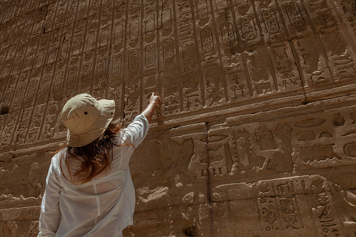 A tourist examines ancient hieroglyphics  at the Edfu temple in Egypt.