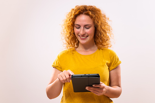 Image of happy ginger woman using digital tablet.