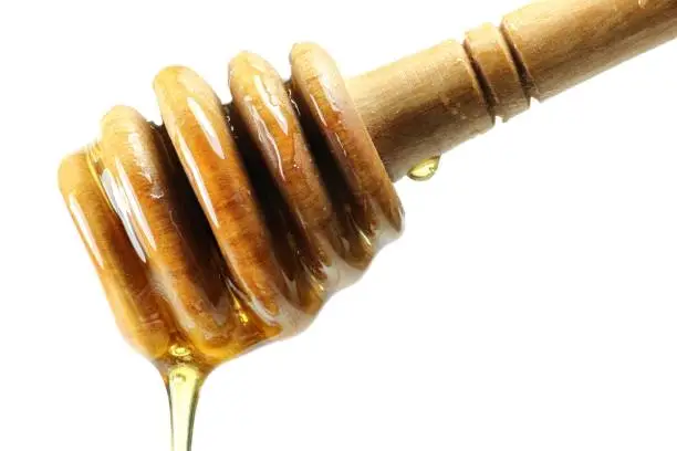 honey spoon made of olivewood against white background