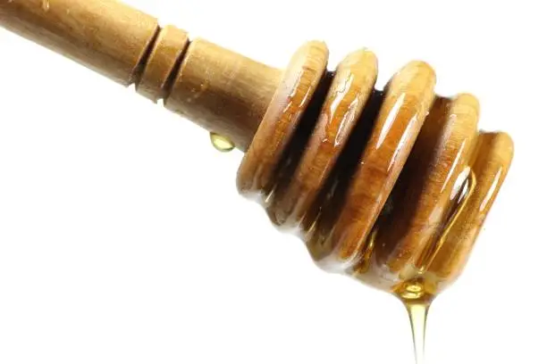 honey spoon made of olivewood against white background