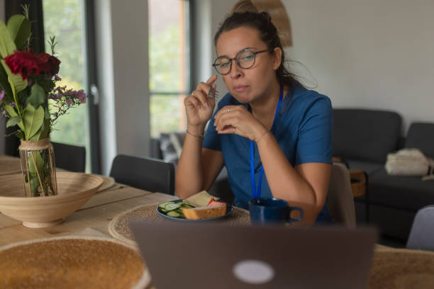 istock Sitting at the dining table at home, a nurse takes a break from work and eats breakfast 1735350711