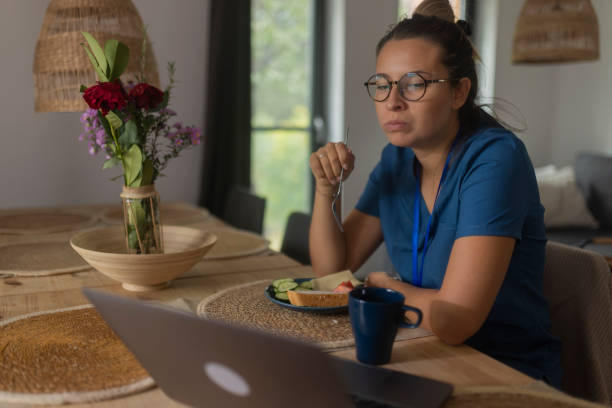 istock Sitting at the dining table at home, a medical technician takes a break from work and eats breakfast 1735350712