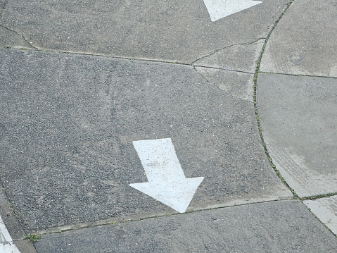 a large white arrow drawn on a section of driveway.