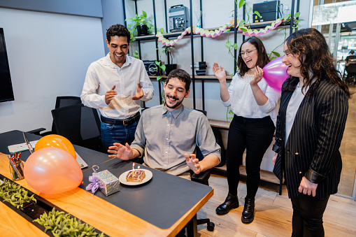 Team celebrating businessman birthday in the office