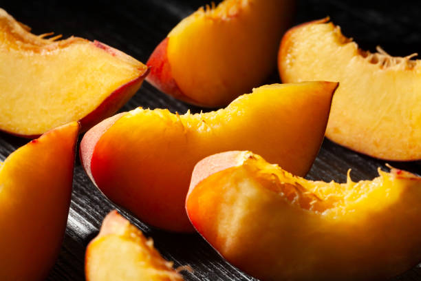 istock sliced peach on wood 1735370348