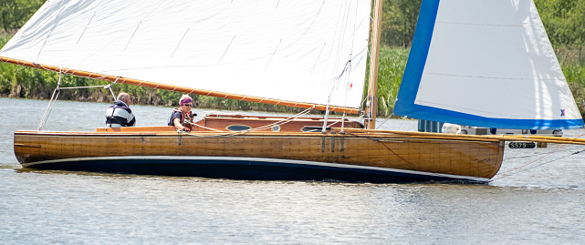 Horning, Norfolk, UK  June 03 2023.  Side on view of a traditional wooden sailboat on the River Bure, Norfolk Broads in the annual Three Rivers Race