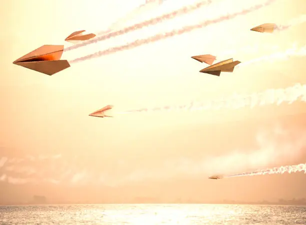 Photo of Flying paper golden planes in subset sky