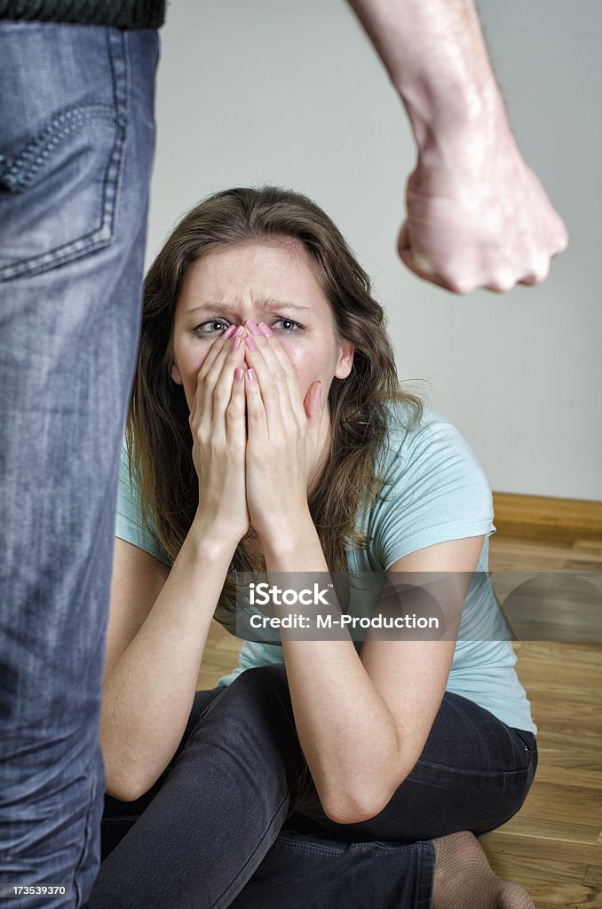 Home violence concept. Frightened woman and men's fist Adult Stock Photo